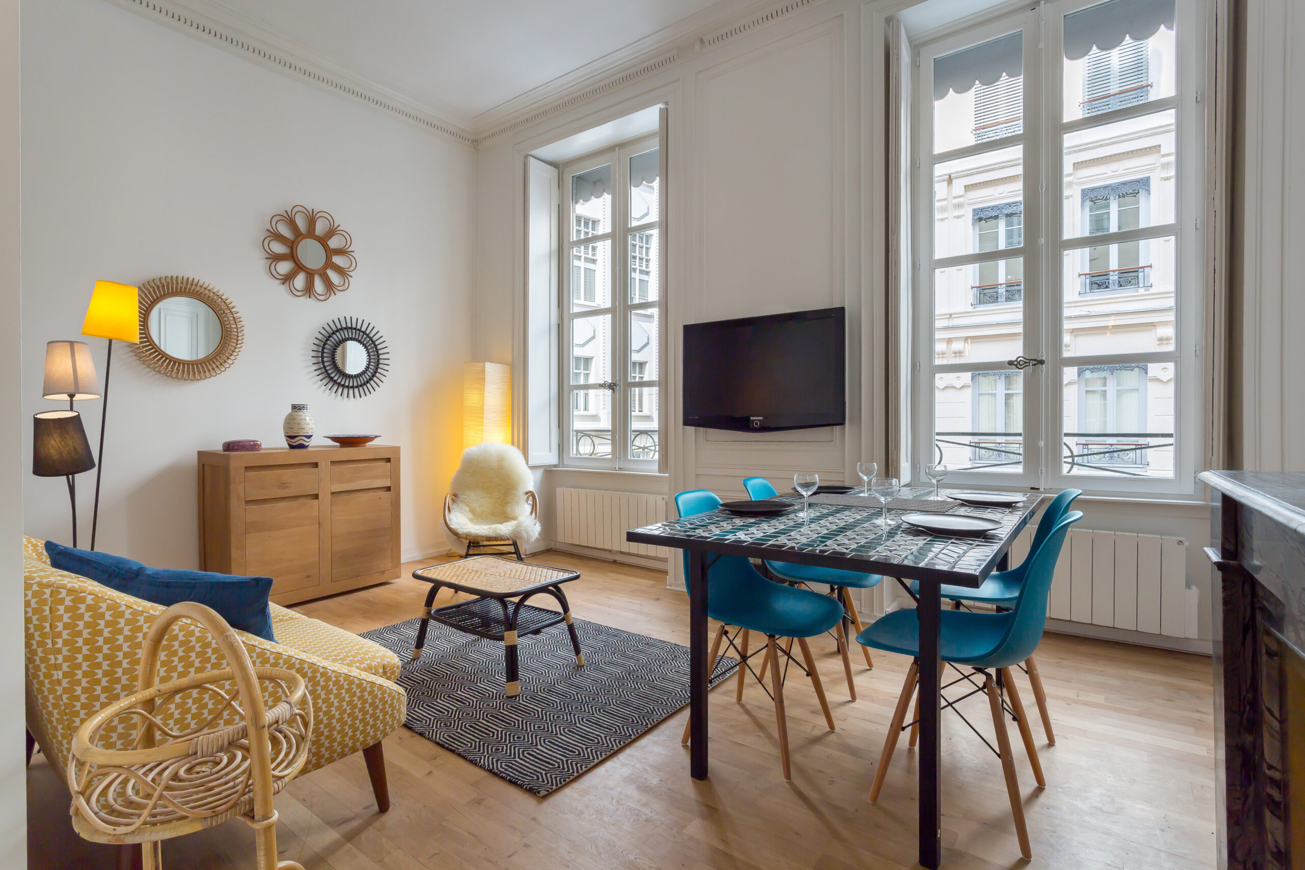 Patchwork — Séjour avec canapé jaune, fauteuil et grandes fenêtres