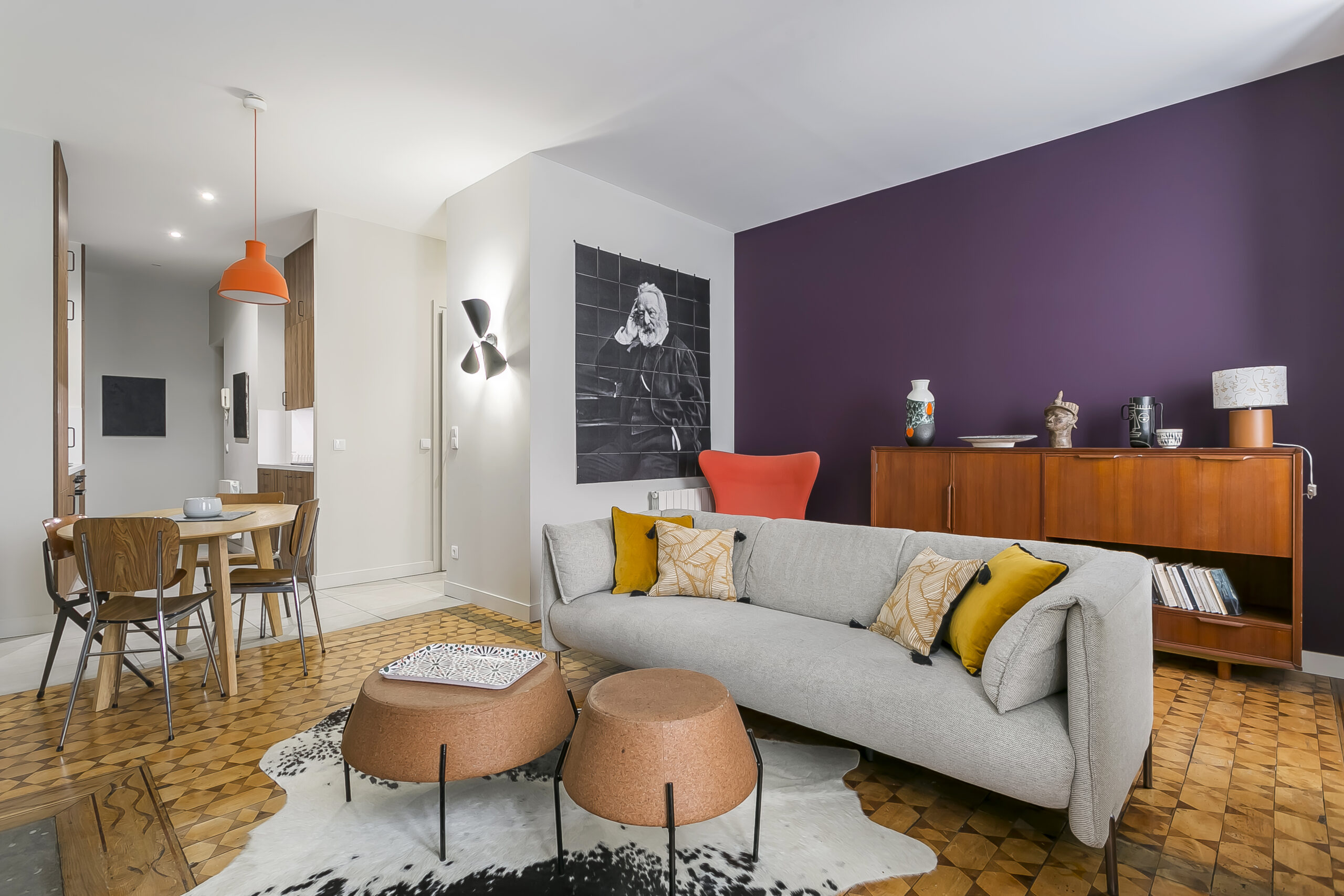 Victor Hugo — Salon avec canapé gris, fauteuil rouge et mur violet