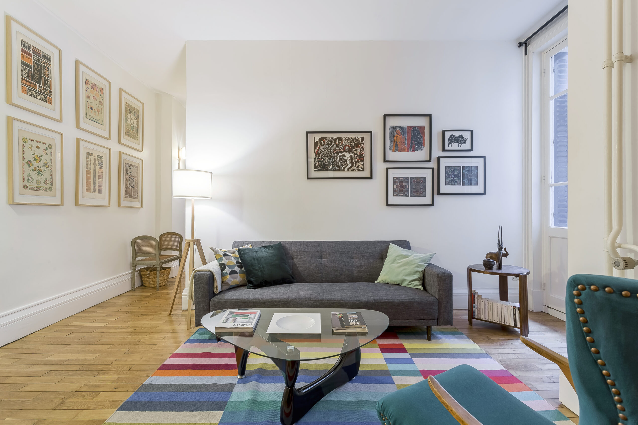 République — Salon avec canapé gris, mur orange et tapis multicolore