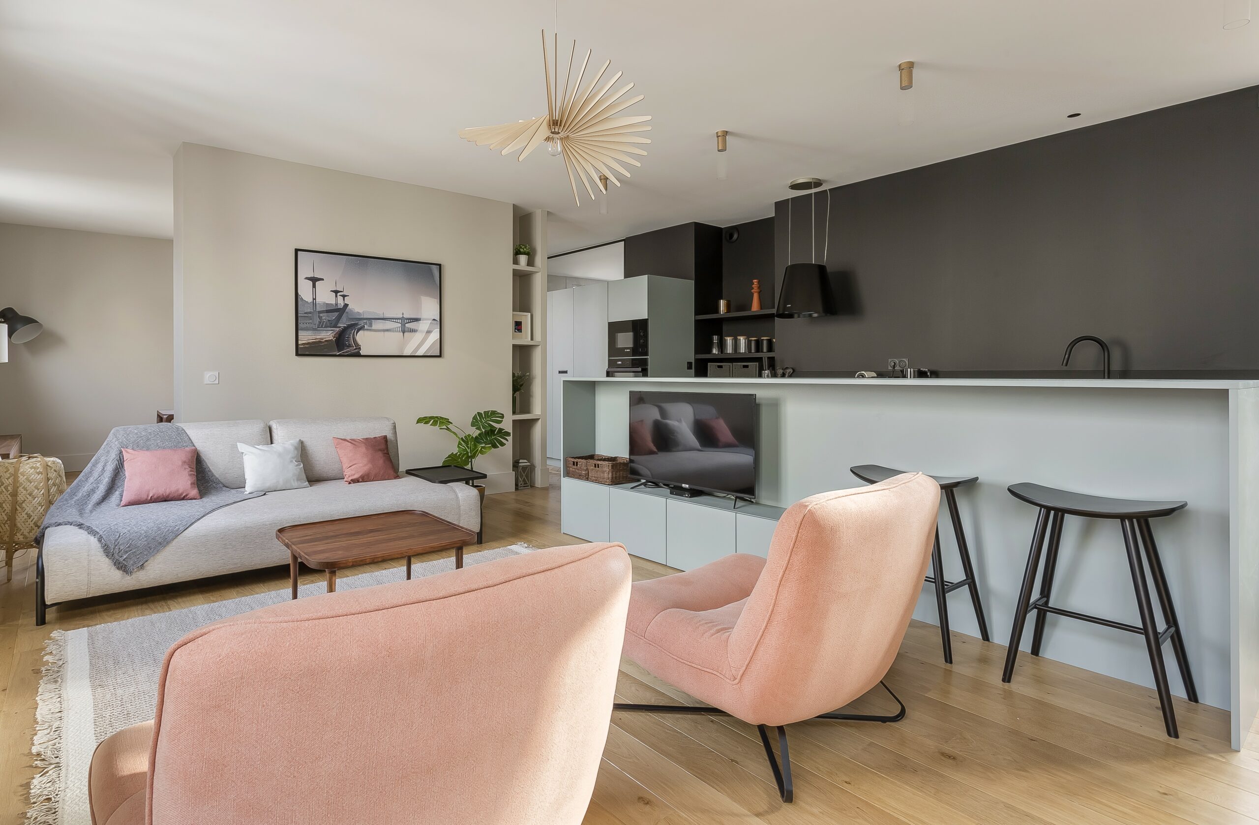 Belle Vue — Séjour lumineux avec fauteuils roses et cuisine ouverte