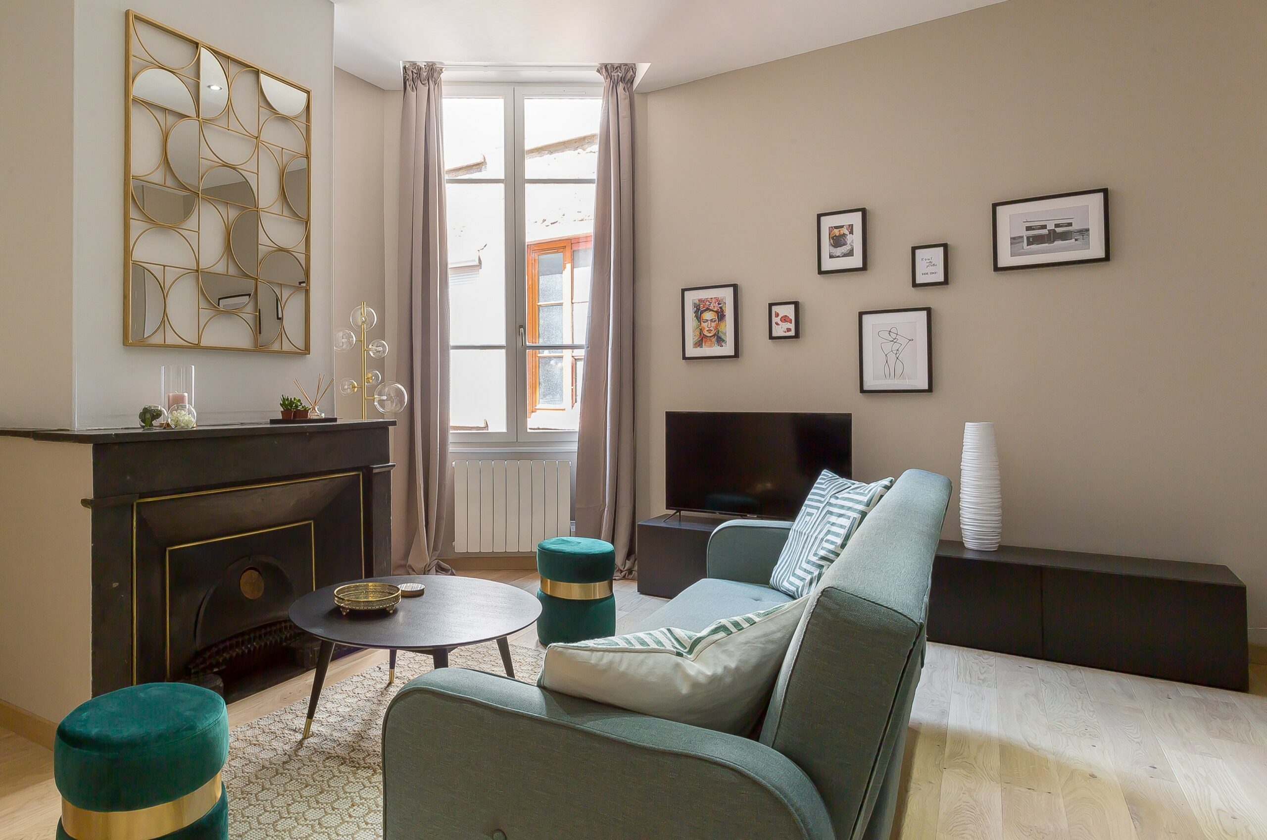 Constantine — Salon avec canapé bleu clair, cheminée et grandes fenêtres