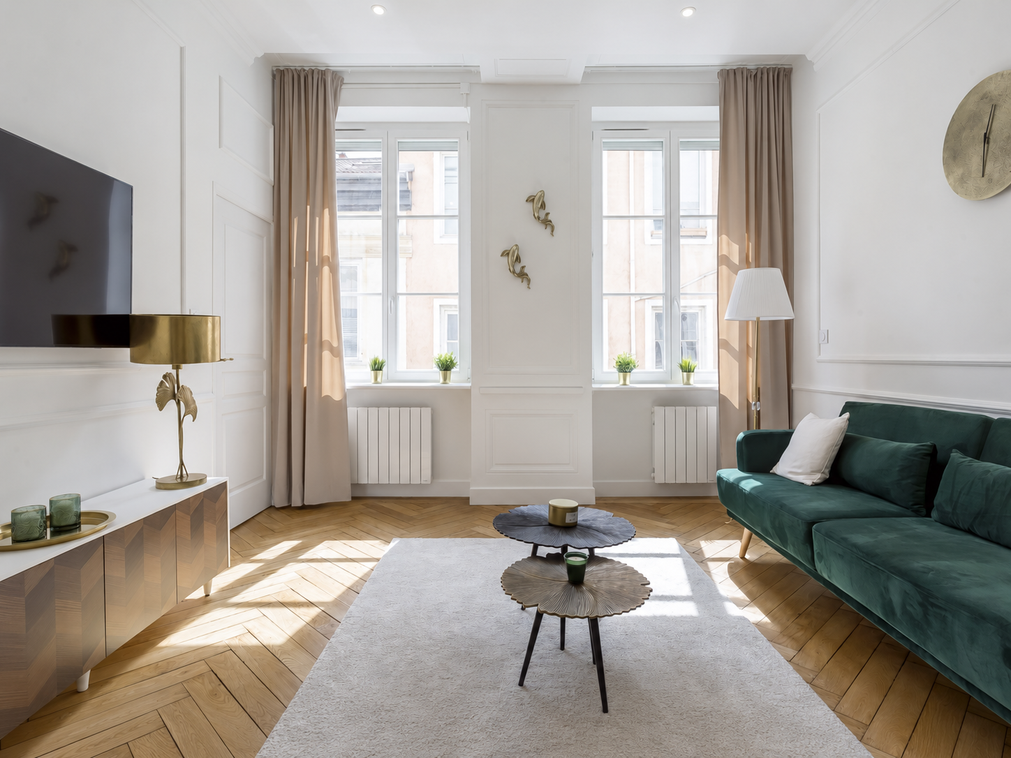 Papyrus — Salon lumineux avec canapé vert, parquet et grandes fenêtres