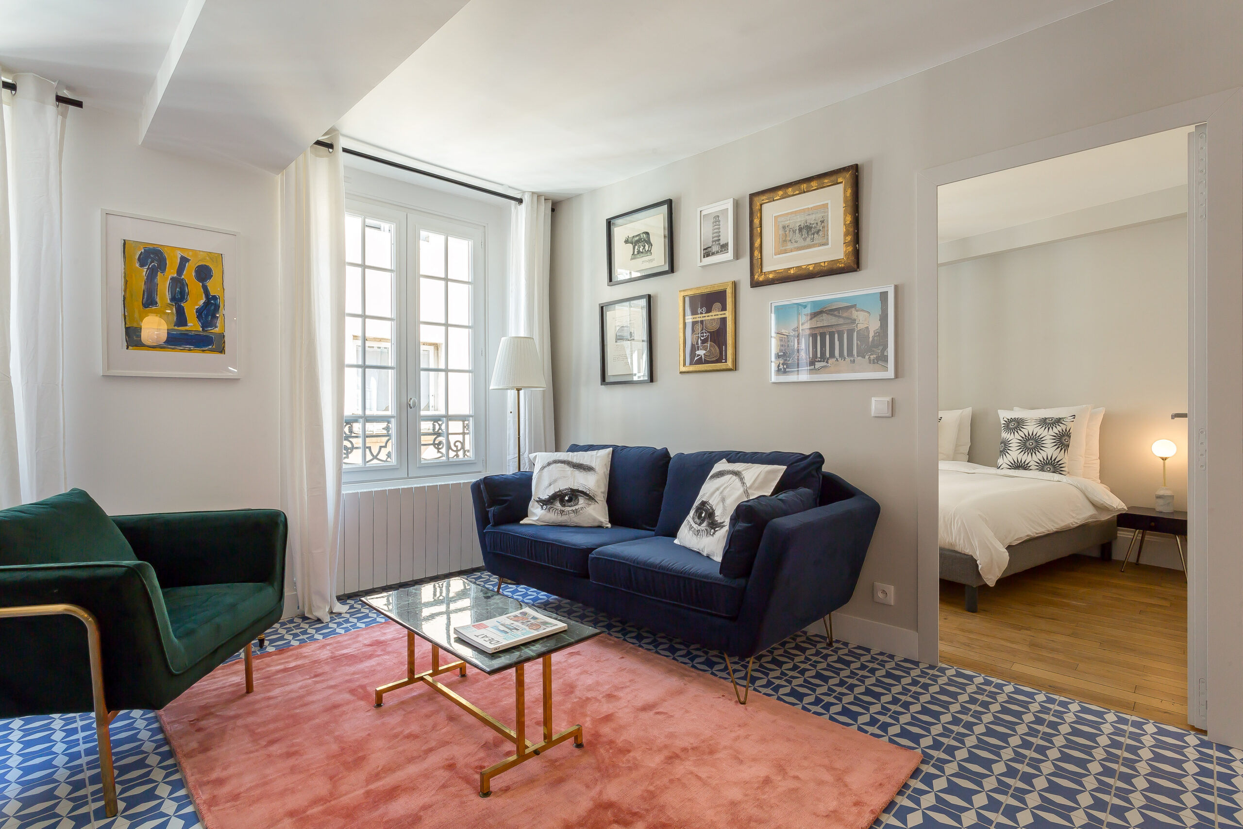 Strada — Salon avec canapé bleu, fauteuils verts et tapis rouge
