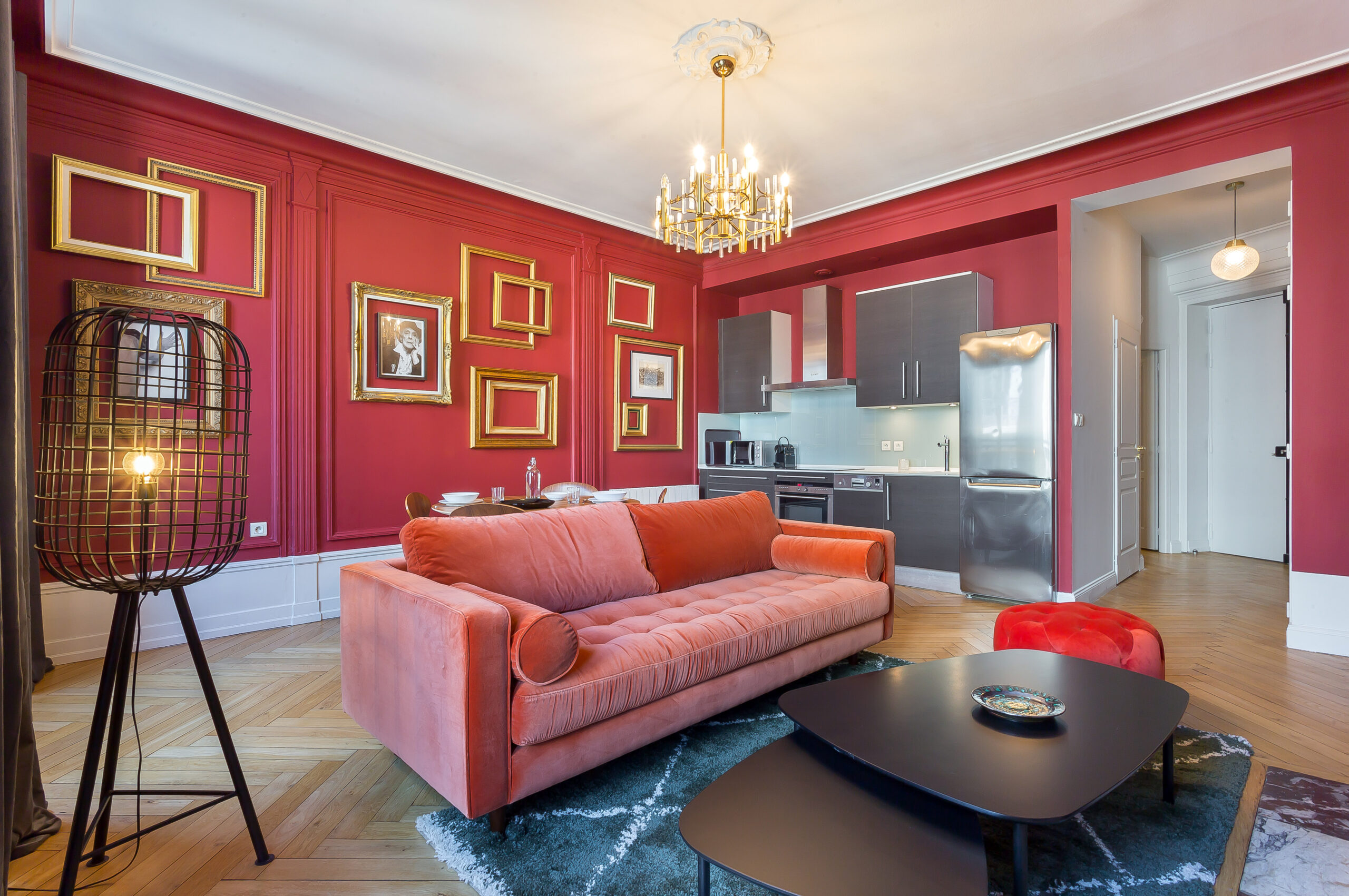Carnot — Salon aux murs rouges avec canapé rose et lustre