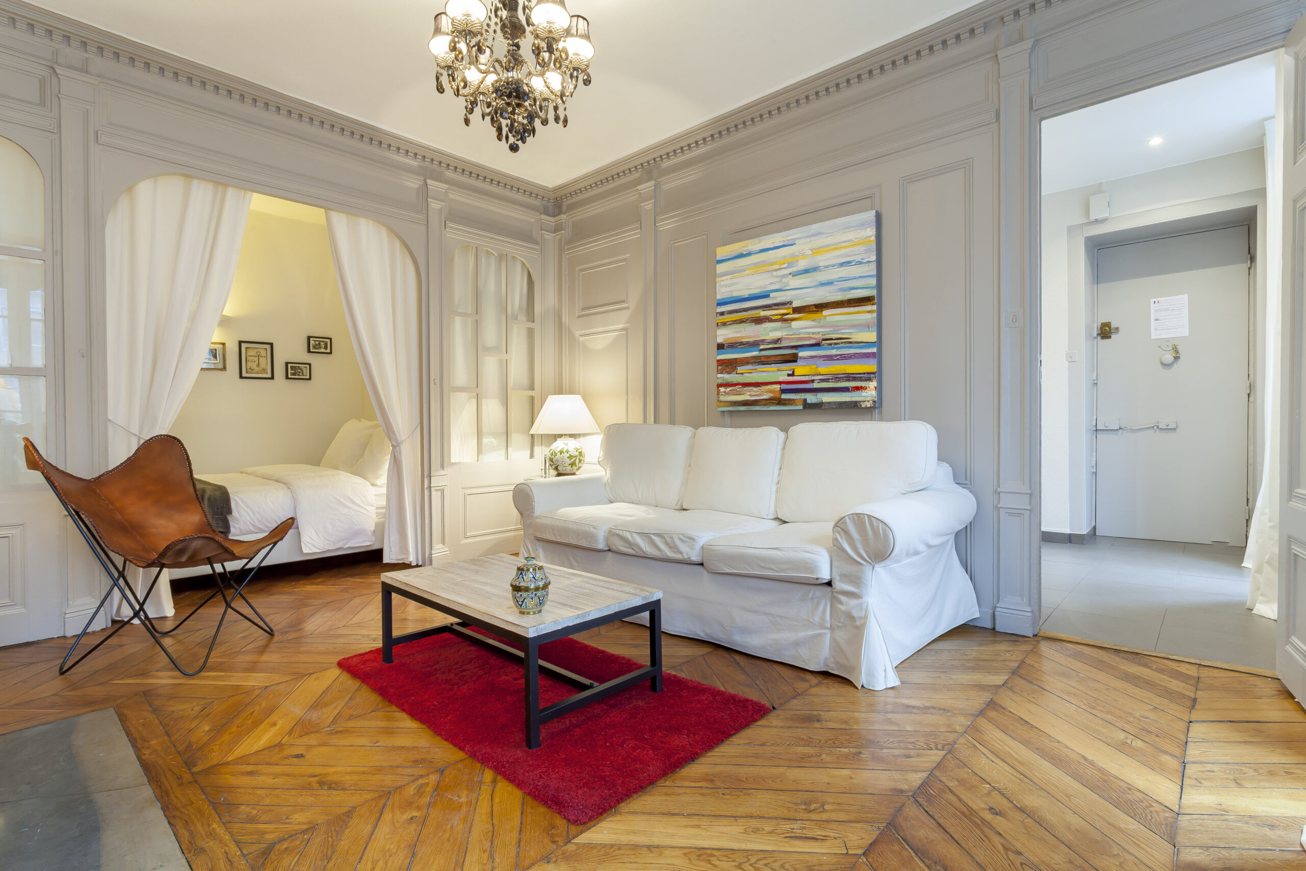 Colombe — Salon avec canapé blanc, boiseries et cheminée