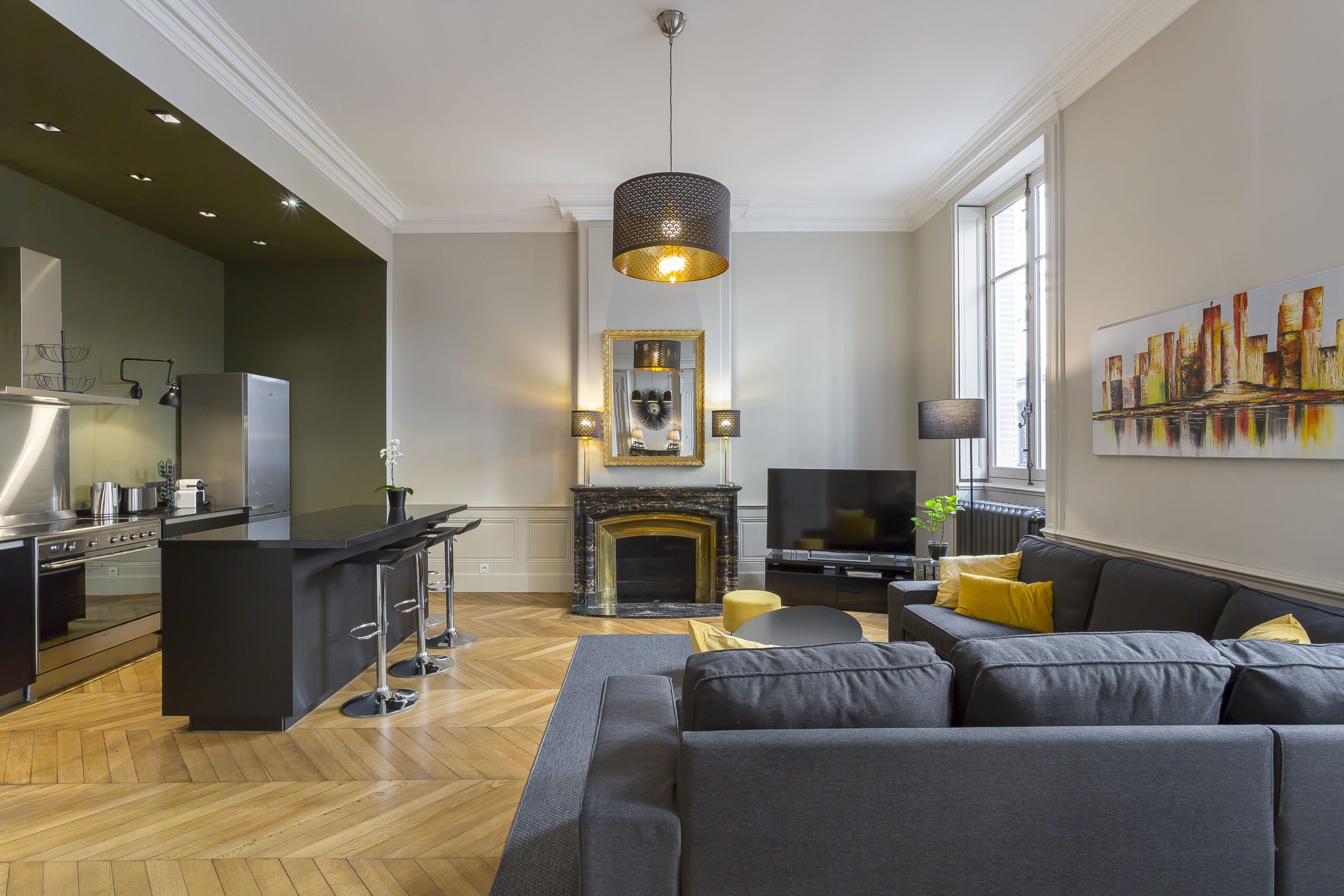 Sala — Salon avec canapé d’angle gris, cheminée et grandes fenêtres