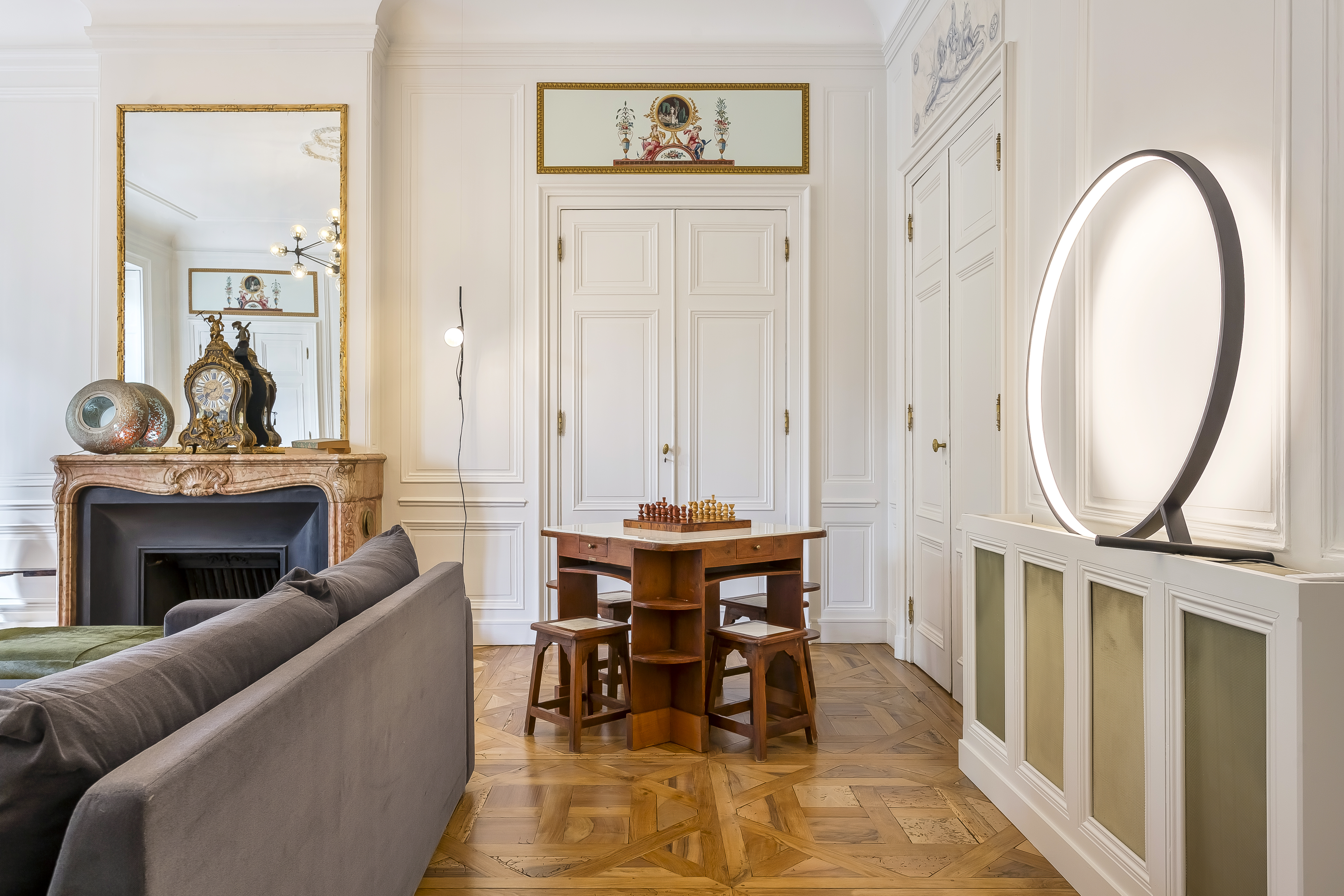 Fireplace, sofa and games table in the Tilsitt apartment in Lyon.
