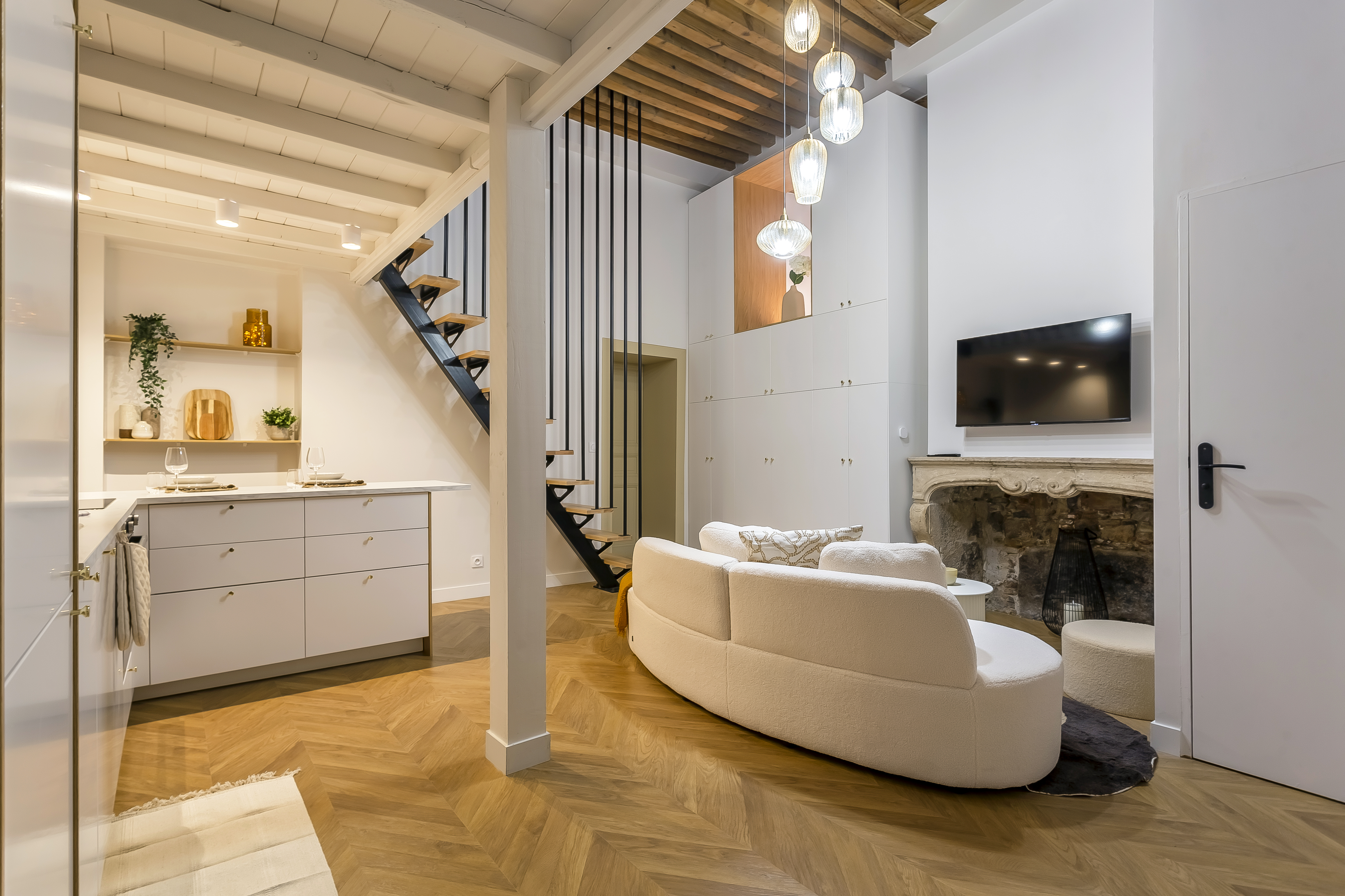 Living area of the Étoile apartment in Old Lyon, with open kitchen, staircase and lounge.