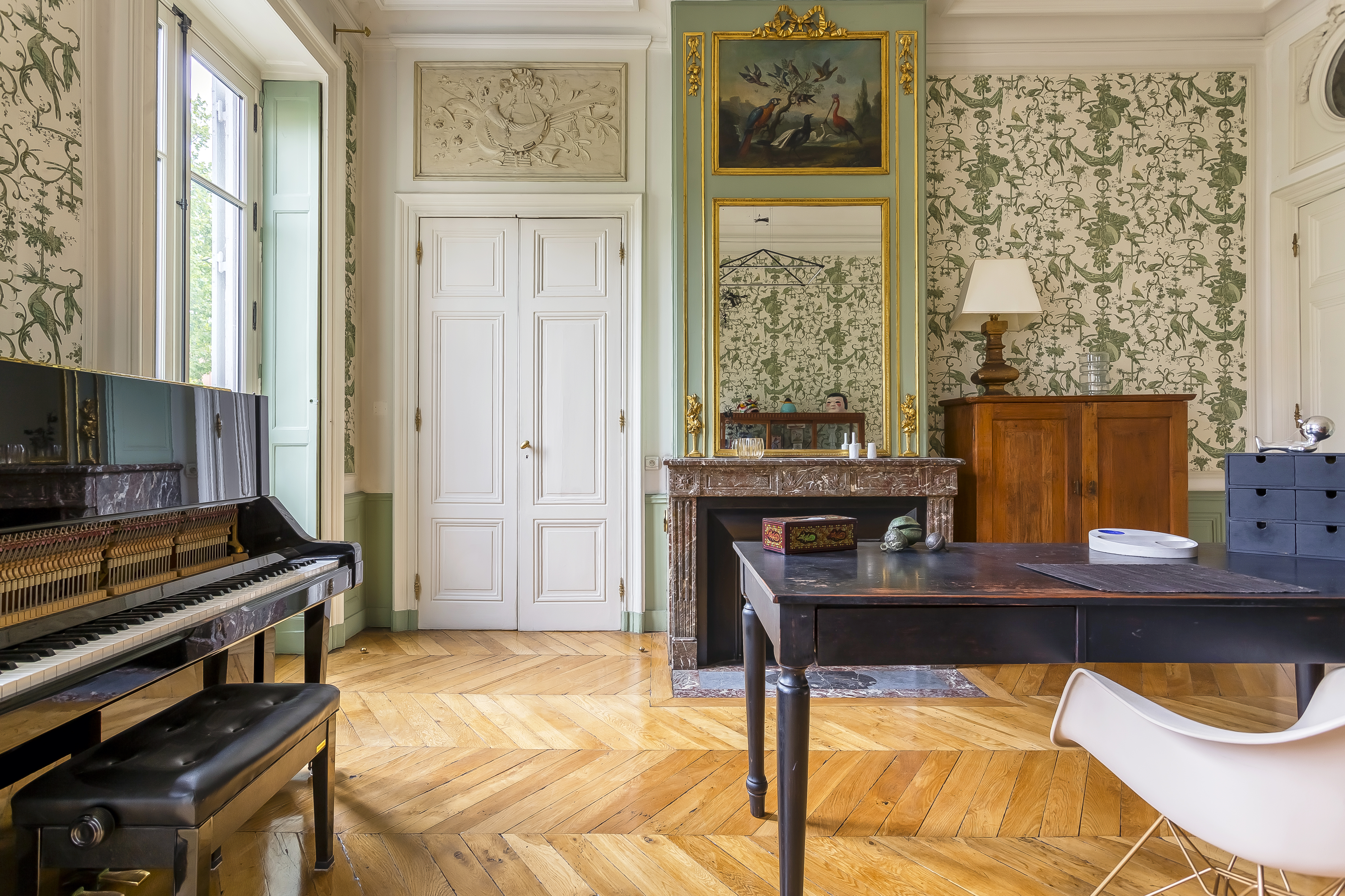 Bureau de l’appartement Tilsitt, avec piano, cheminée et grand miroir.
